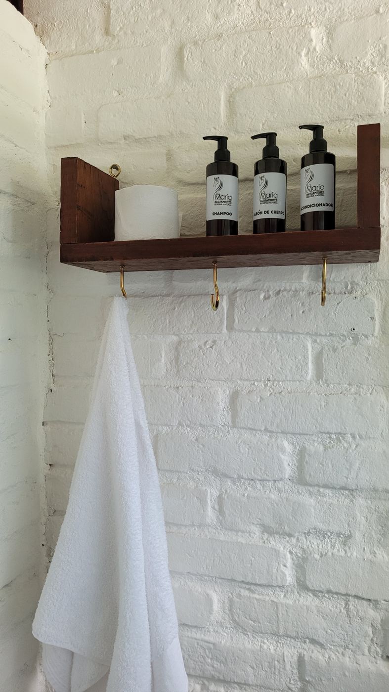 Repisa con productos de aseo y toalla en el baño de la habitación 2