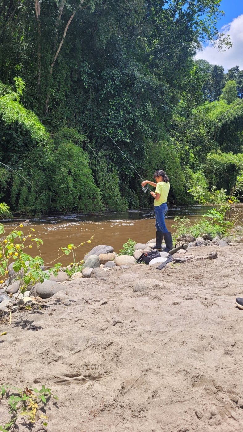 Niña pescando a la orilla del río en la reserva